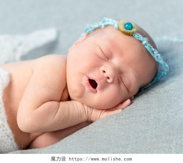 温柔刚出生的婴儿睡在毯子上的头上的花环